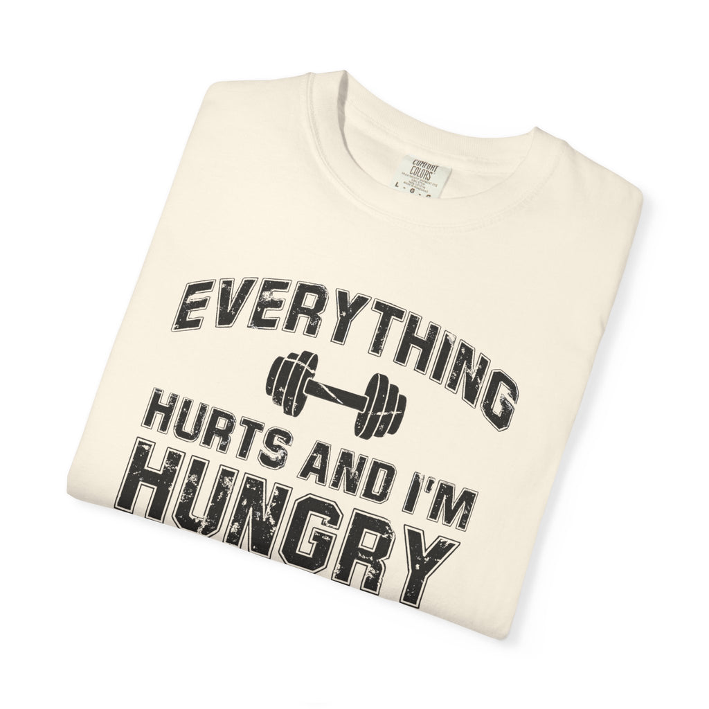 Folded t-shirt with 'Everything Hurts and I'm Hungry' text on a white background