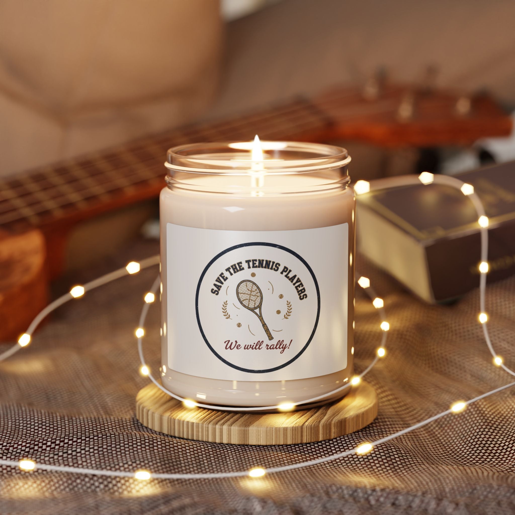 Candle in a jar with a label featuring a tennis racket on a wooden surface with string lights.